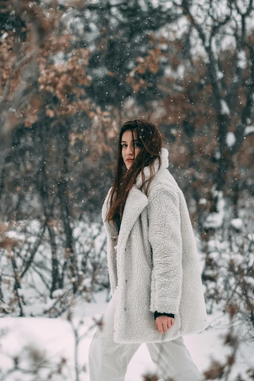 a woman walking through the snow in her winter coat