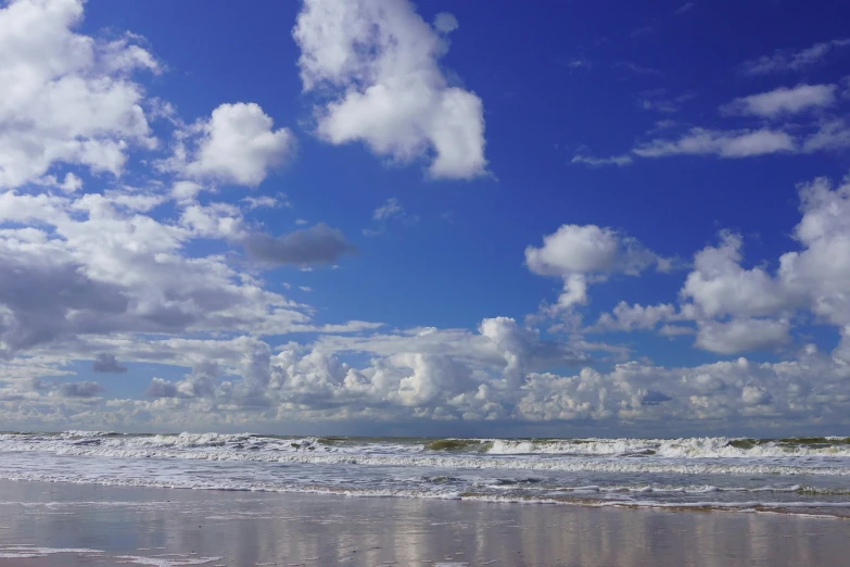 people are walking in the ocean on the beach