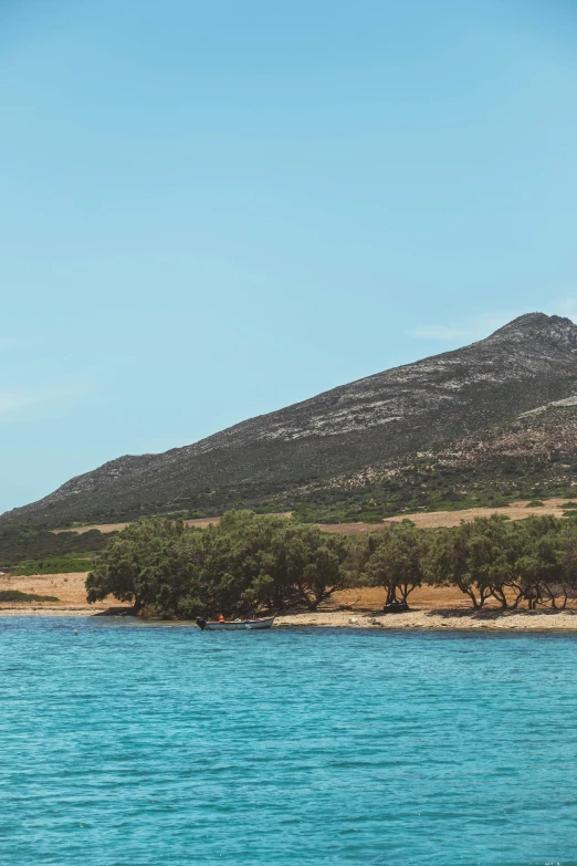 a very tall mountain above the water and trees