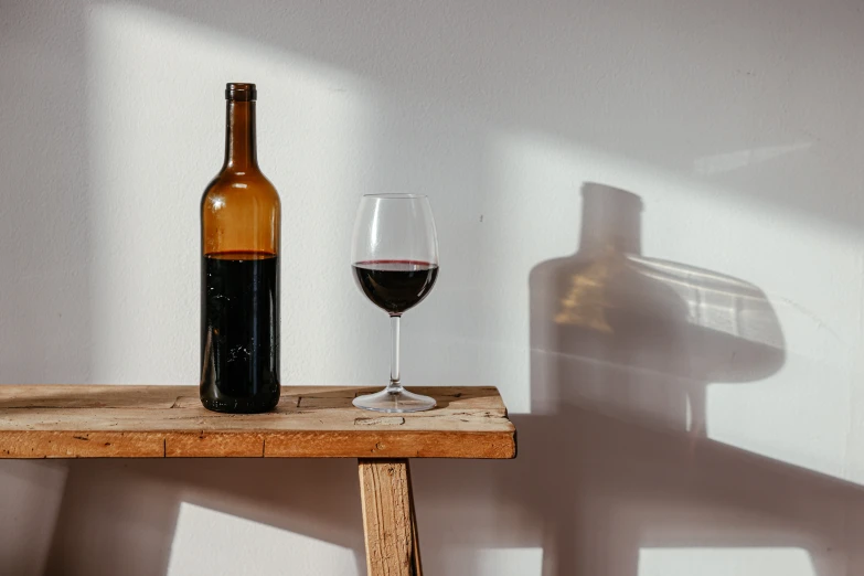 a glass of wine is next to a bottle of wine