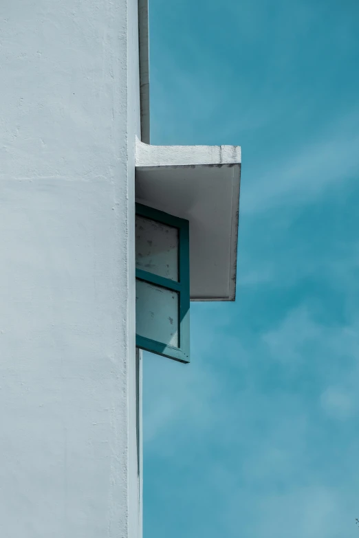 the corner of a building with a window and no curtains