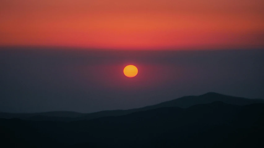 a very large sun sitting in the middle of a cloudy sky