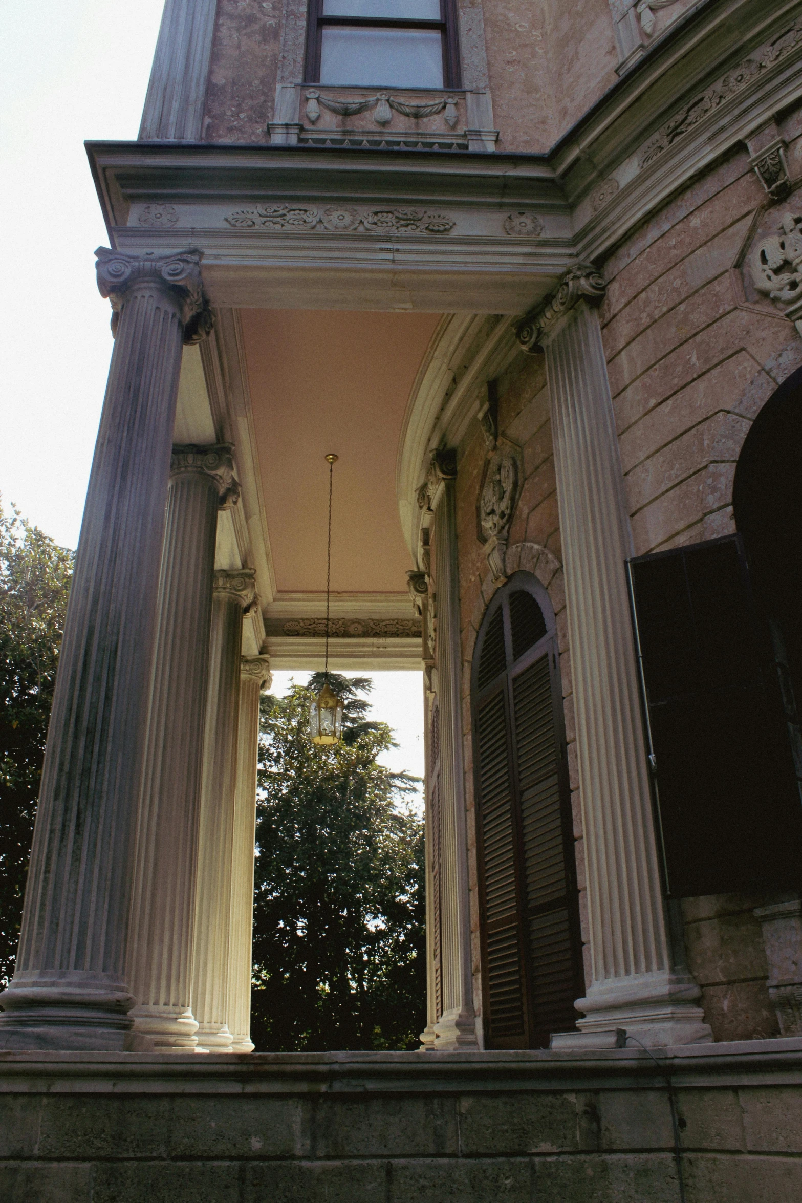 columns on either side of a stone wall and doorway leading to a clock