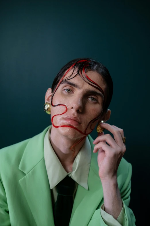 a man in a green suit and matching red paint painted on his face