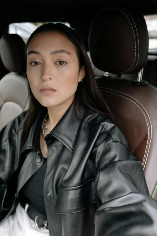 a beautiful young woman sitting in the front seat of a car