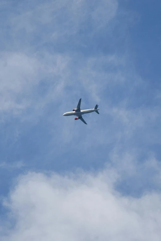 an airplane flying in the sky with a cloud