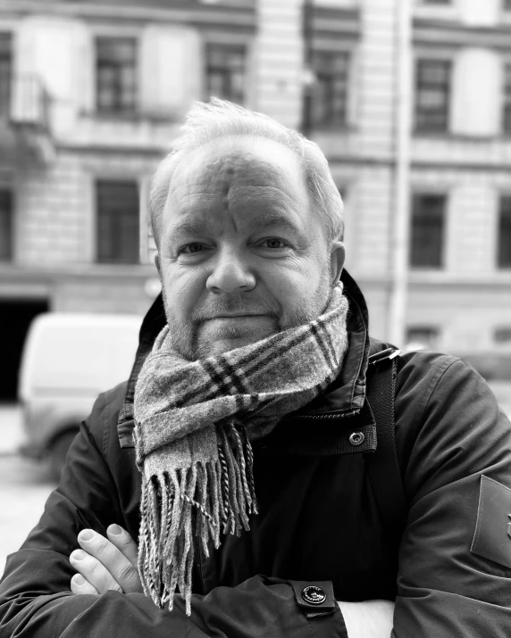 an older man with a scarf around his neck