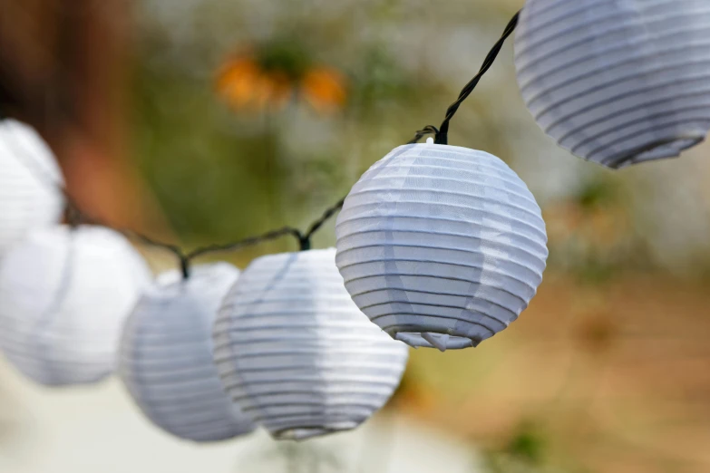 chinese lanterns hanging from a string on the side of a road