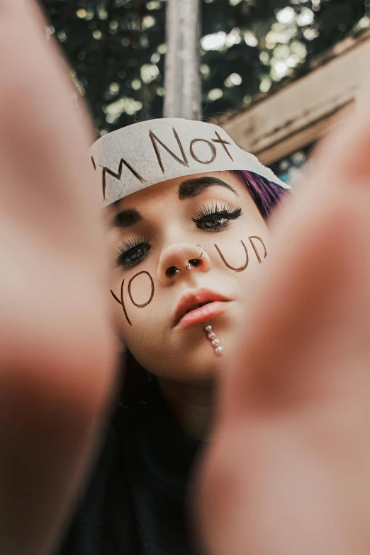 a girl has writing on her face with her hands