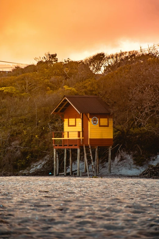 a small house on stilts sits atop the water