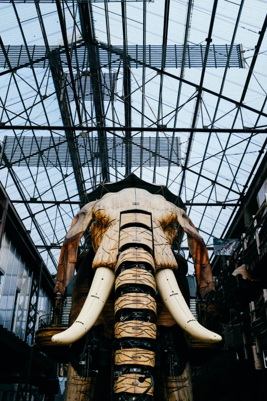 a huge sculpture of an elephant made of wood in a warehouse