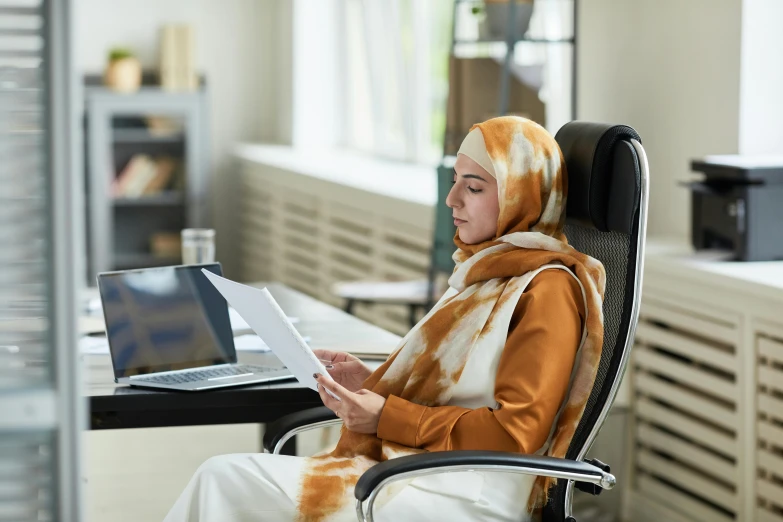 a woman with a cow print scarf is sitting in a chair