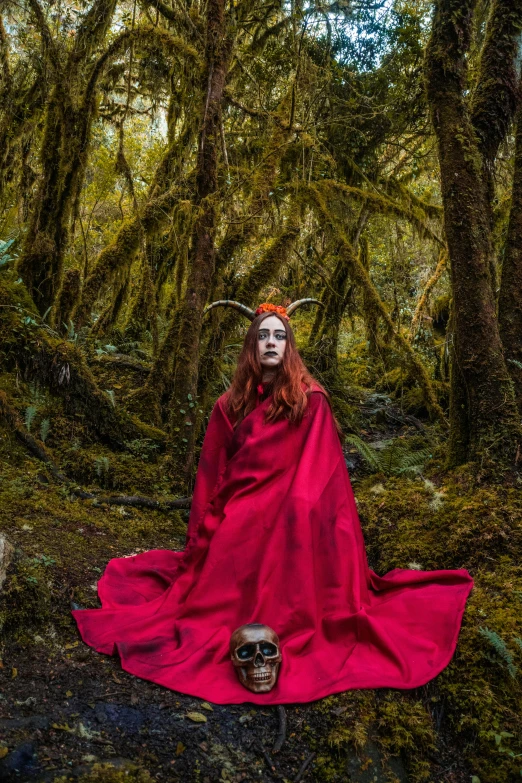 a woman is sitting in the middle of a forest