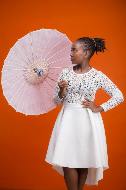 a woman holding an umbrella and wearing a white dress