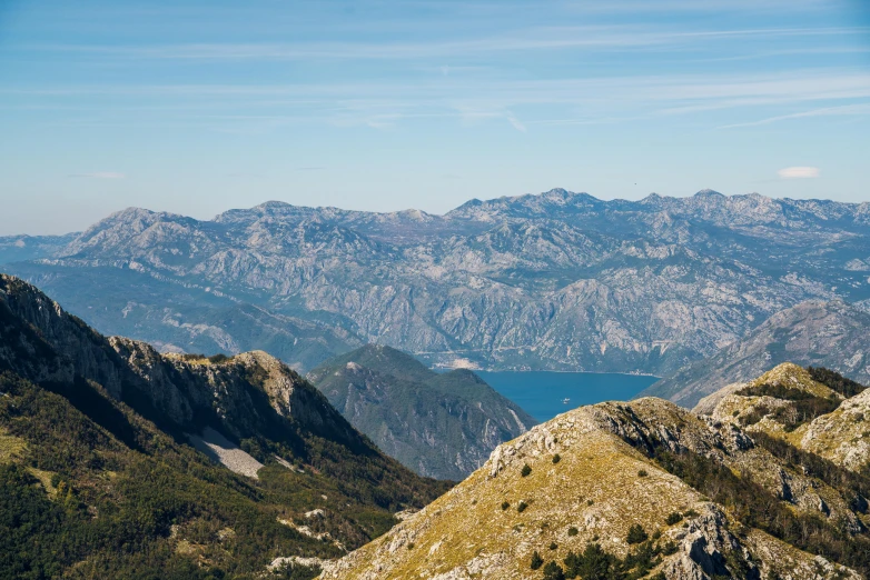 some mountains with trees and water in the distance