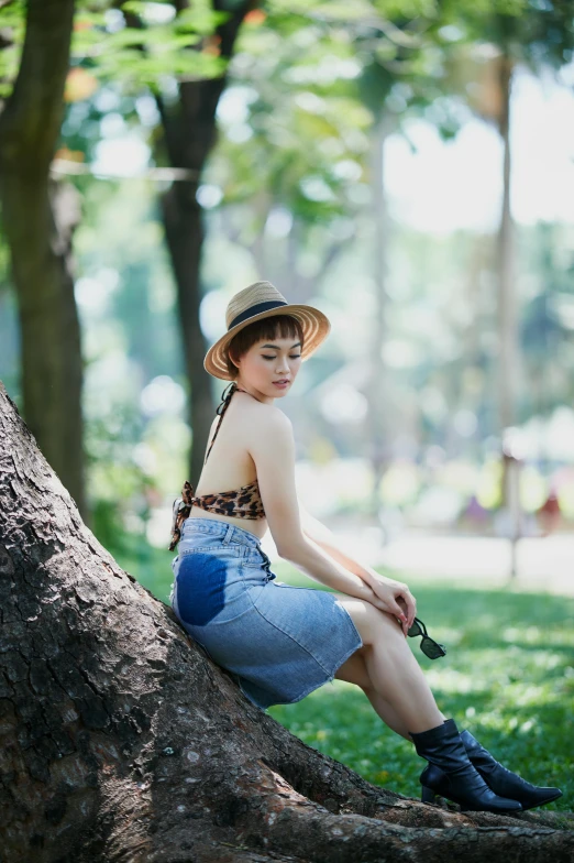 a woman sitting in the middle of a park on a tree