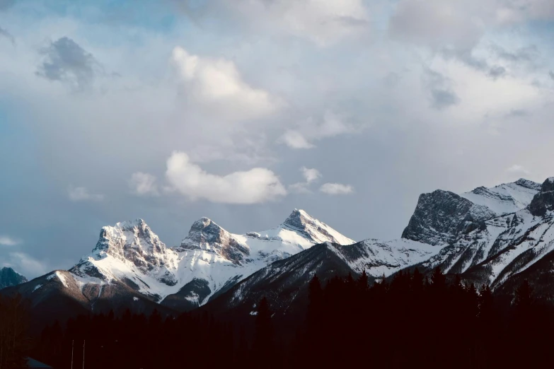 snow capped mountain range in the distance under partly cloudy sky