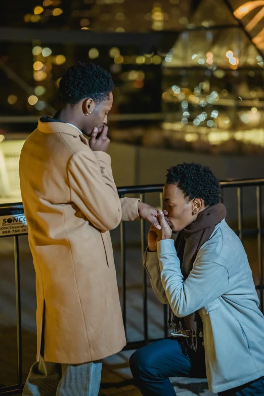 two people standing next to each other touching hands