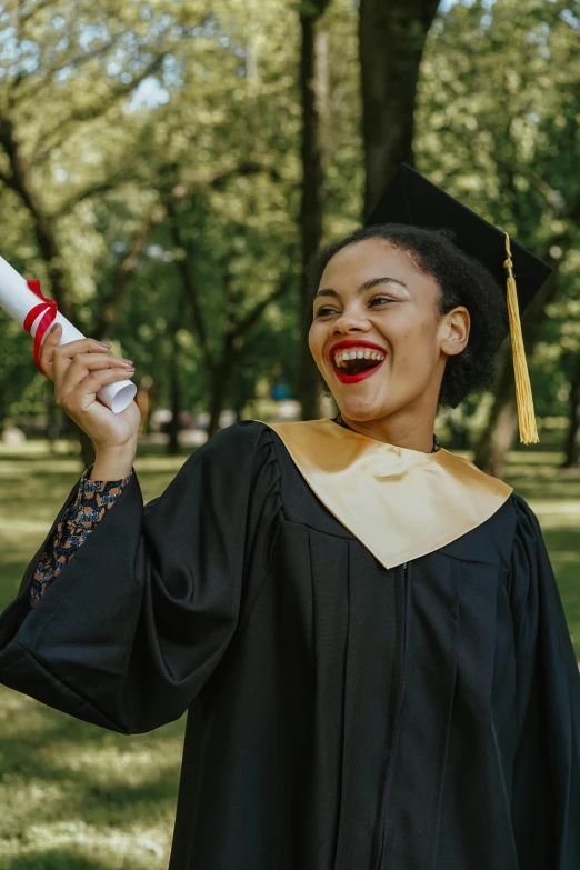 a woman is in the park holding a diploma