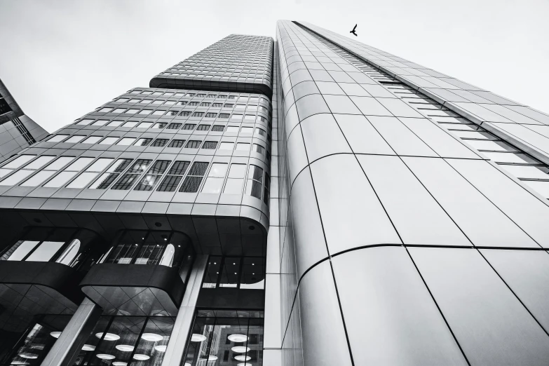 looking up at a tall building with an airplane flying overhead