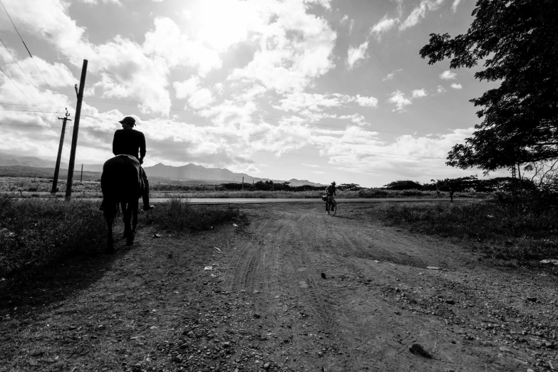 two people on horses riding down the street