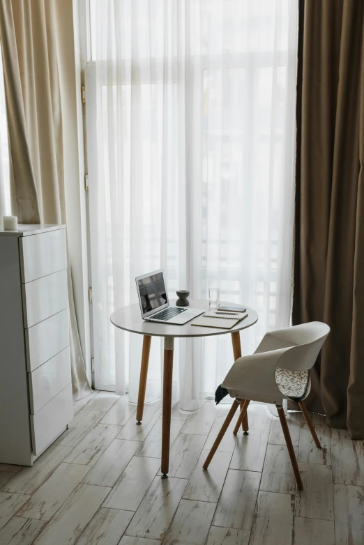 a chair and table are in front of the window