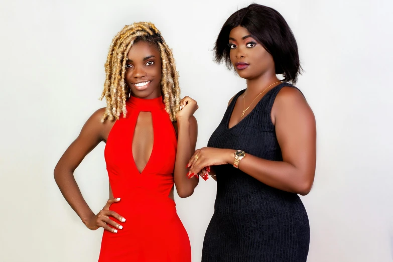 two women stand in front of a white wall