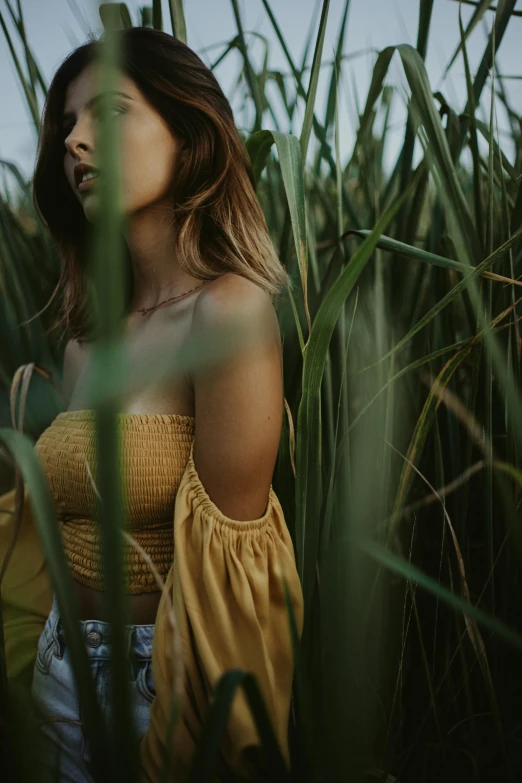 young woman posing for picture in a tall grass field