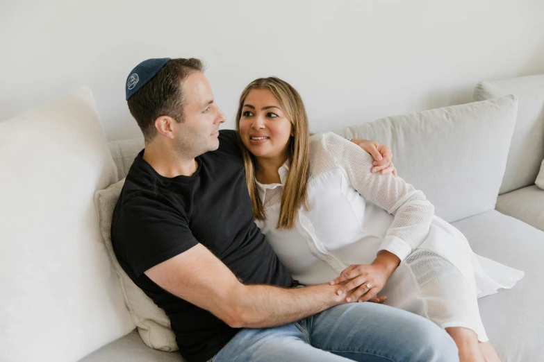 the couple are posing on the couch while smiling at each other