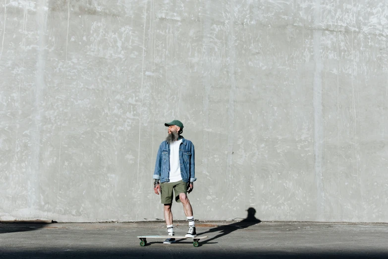 a person is standing in front of a concrete wall with a skateboard