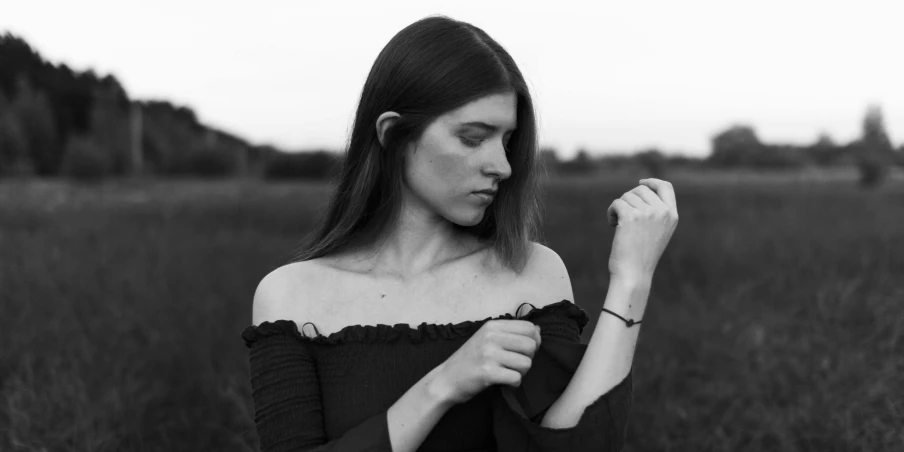 a woman in an open field holding a banana