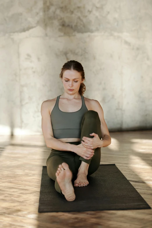 a woman with red hair sitting on top of a mat