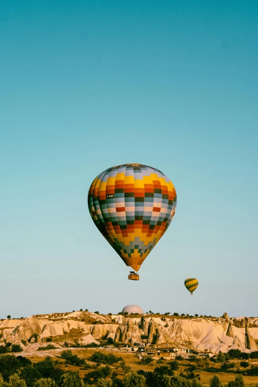  air balloons in the air over desert terrain