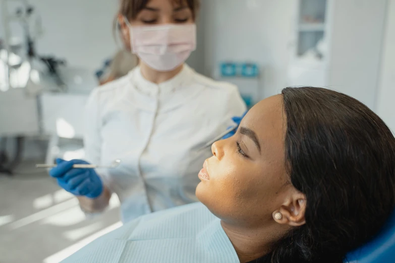 two young women in medical equipment working on an older woman