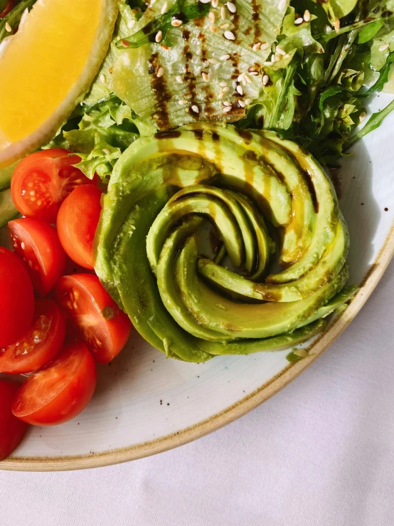 an avocado and tomatoes are on a plate