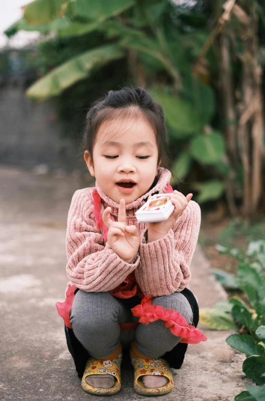 the child is eating food outside and smiling