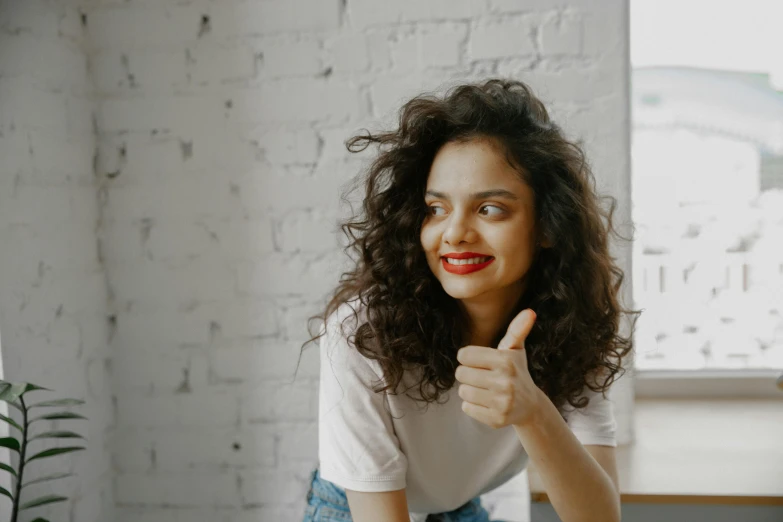 a lady giving a thumbs up in her office