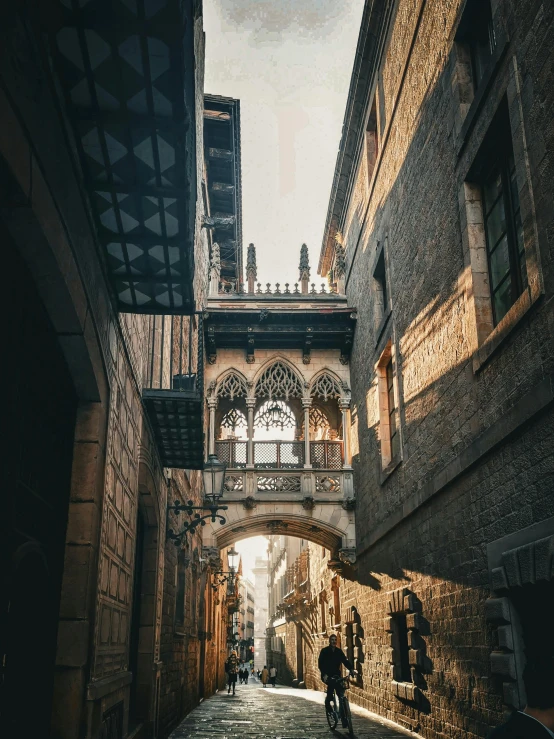 two people walking on the pavement under an arch