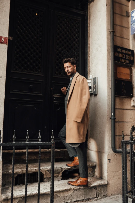 a man is standing outside his door looking at the camera