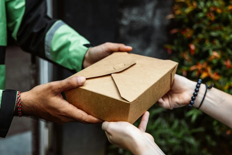 someone is giving out the brown box to another person