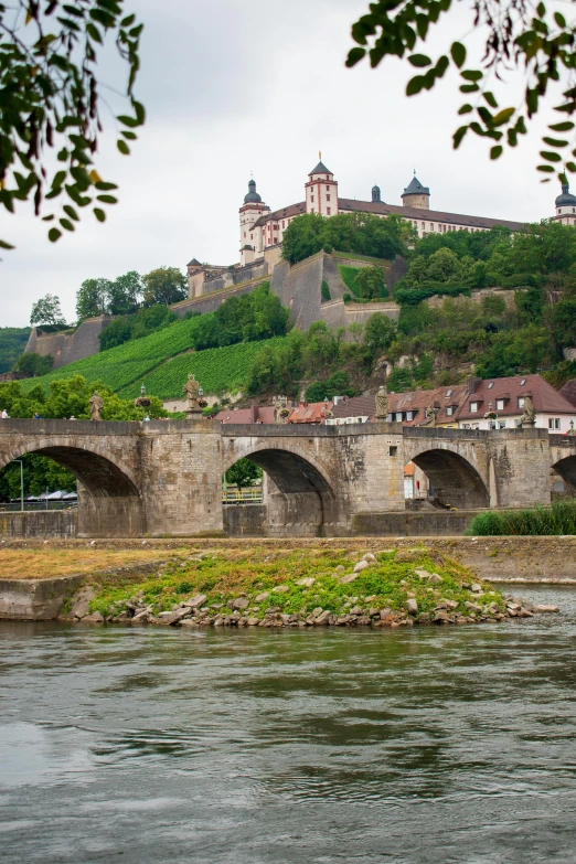 view of medieval bridge leading to town near river