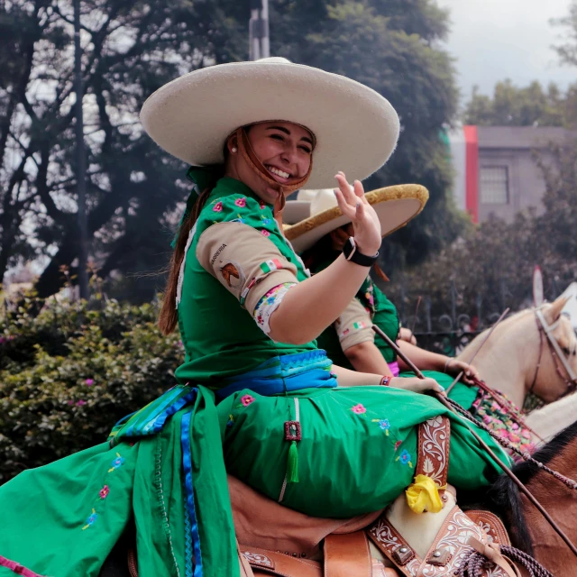 a smiling mexican sitting on the back of a brown horse