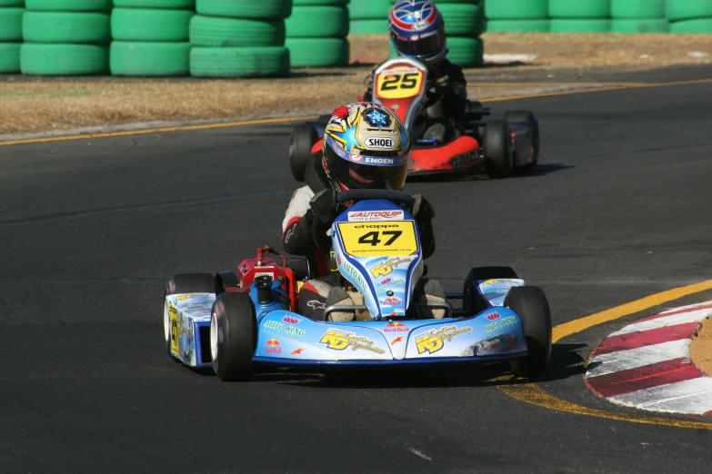 two people riding go kart racing cars on the road
