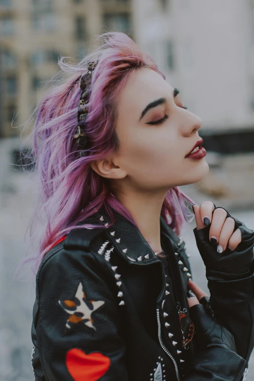 a woman with purple hair in a black jacket