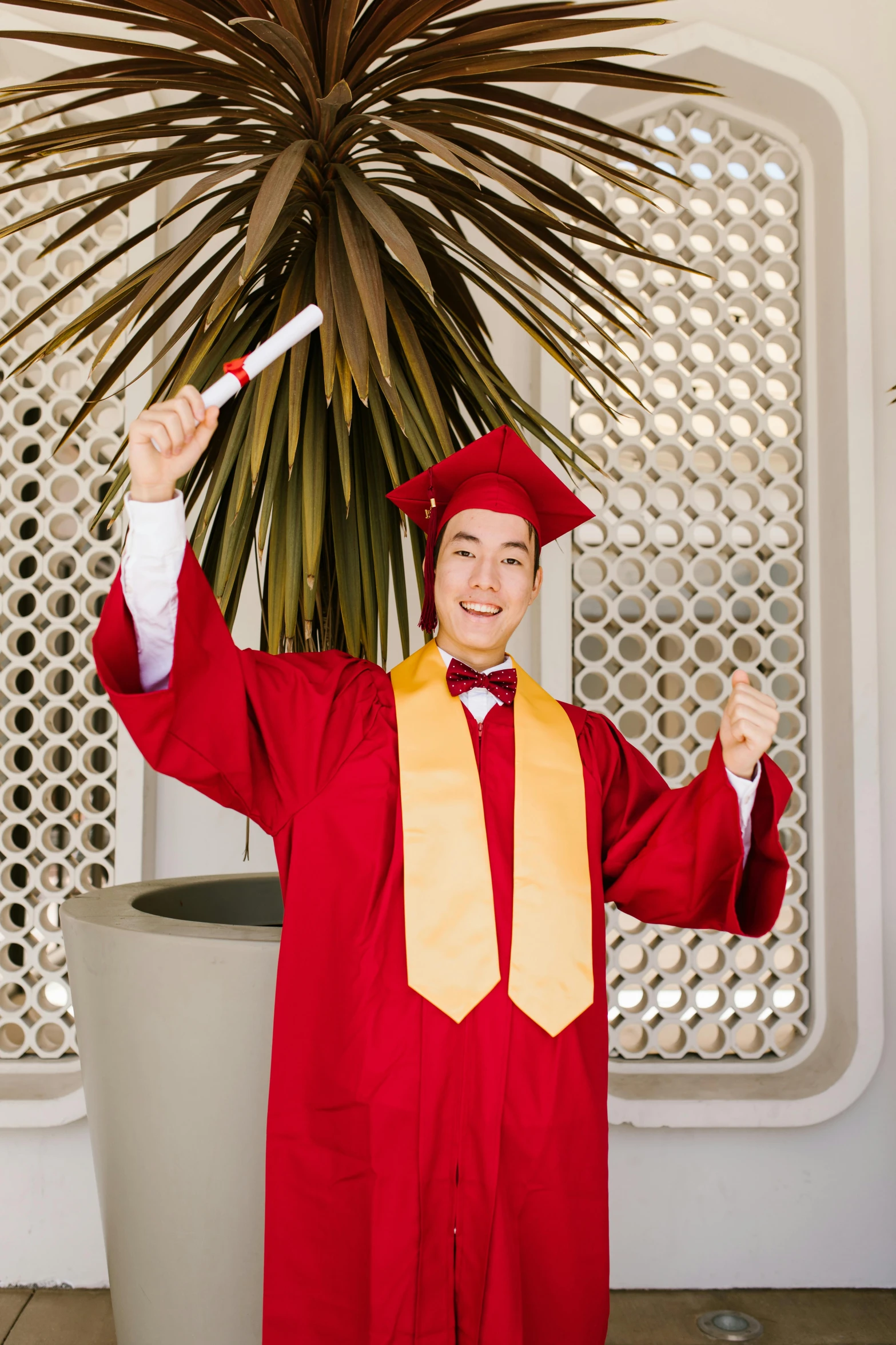 a boy in his graduation gown is doing some exercises