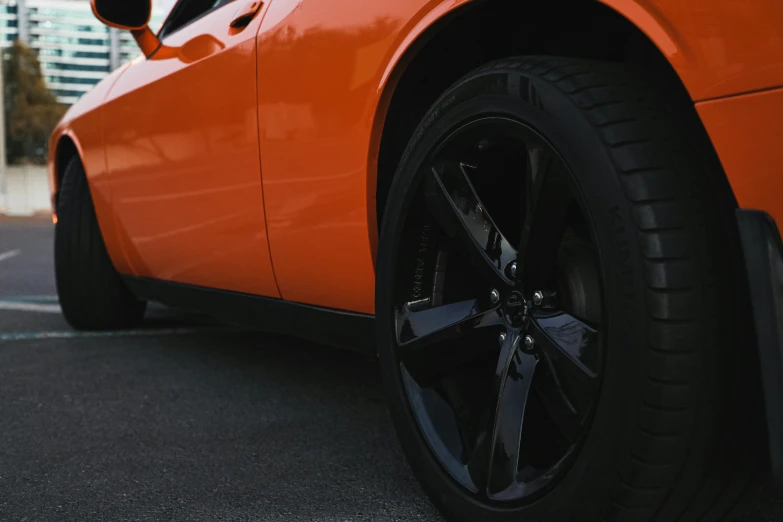 the tire on an orange car is parked