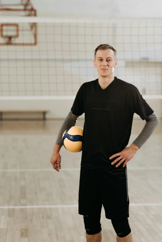 an athlete is standing with a volleyball near the net