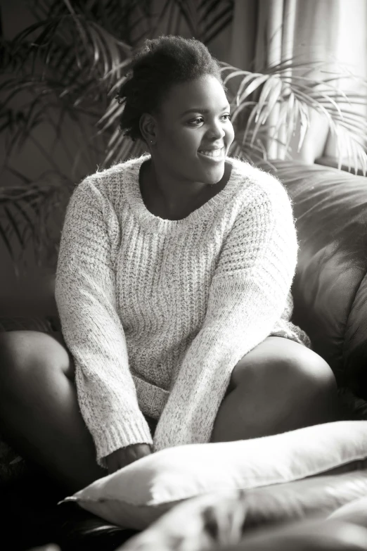 a woman sitting on a couch next to pillows