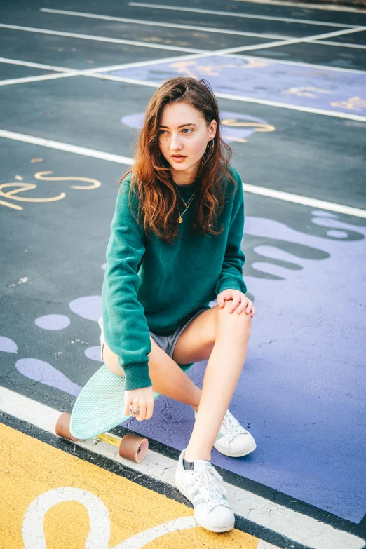 a girl sits on the sidelines of a basketball court