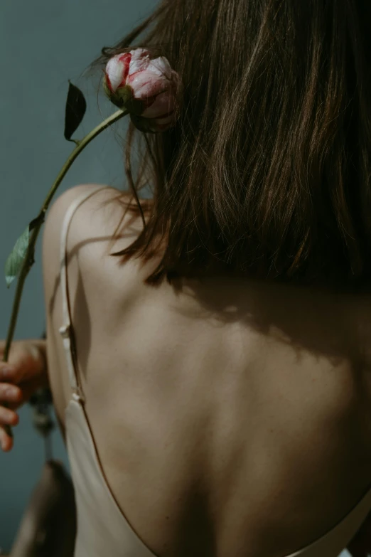 a woman with a rose in her back, while another girl puts on her 